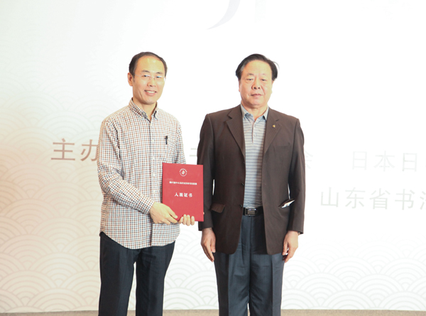 张业法代表中国书法家协会向中方参展作者代表颁发“入展证书”